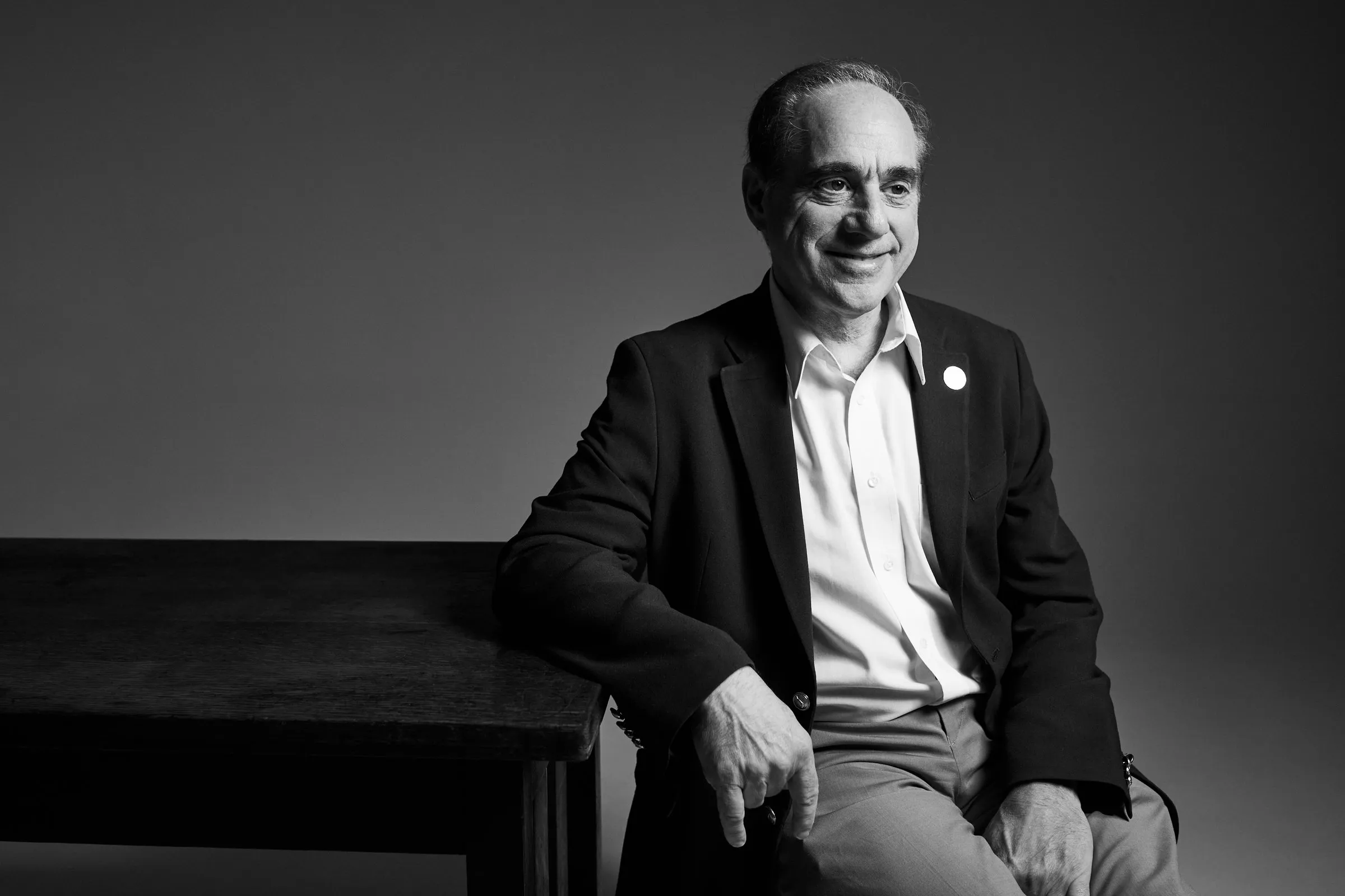 David J. Shulkin, posing next to table in black and white.